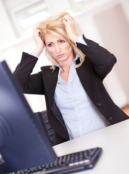 Stressful business woman working on computer at the office