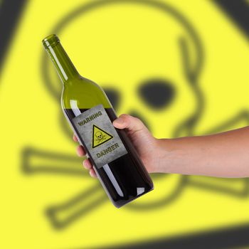 Hand holding a bottle with a warning, poison