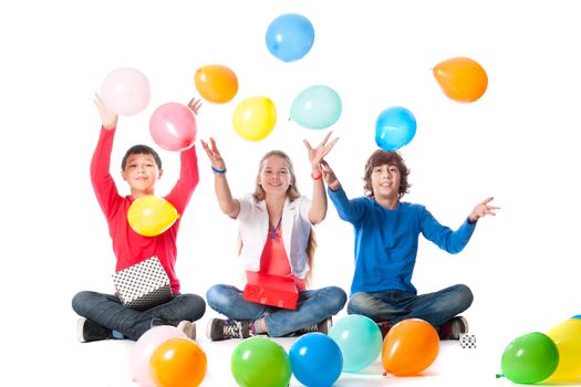 a birthday girl with her two friends with presents and balloons on a white background