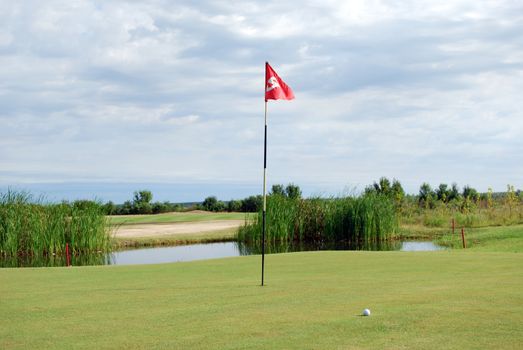 golf course with red flag and ball