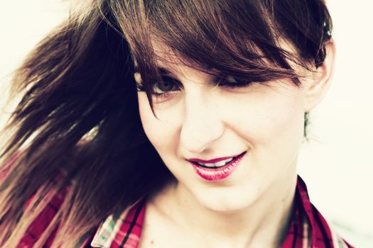 Portrait of a pretty fashionable, young woman in a chequered red shirt on the beach