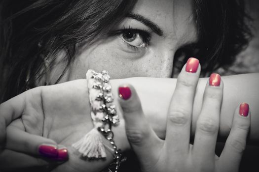 Beautiful young woman portrait with jewellery, close up, eyes focus. Fashion, beauty. Black and white with red nails