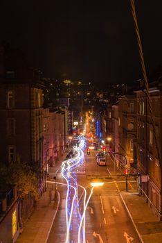 STUTTGART, GERMANY - NOVEMBER 9, 2013: Vivid night scenery showing light traces of cars passing by in long exposure at a intersections along Schwabstrasse on November 9, 2013 in Stuttgart, Germany. The crossroads between Schwabstrasse and Rotebuehlstrasse in Stuttgart West is one of the main streets in Stuttgart.