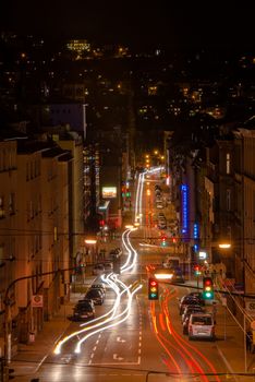 STUTTGART, GERMANY - NOVEMBER 9, 2013: Vivid night scenery showing light traces of cars passing by in long exposure at a intersections along Schwabstrasse on November 9, 2013 in Stuttgart, Germany. The crossroads between Schwabstrasse and Rotebuehlstrasse in Stuttgart West is one of the main streets in Stuttgart.