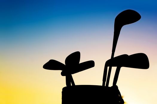 Golf equipment silhouette. Professional clubs in a baggage at sunset