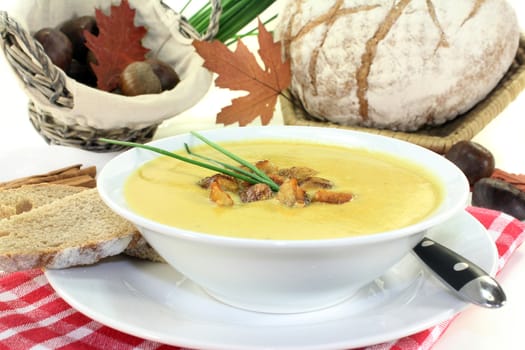 a bowl of sweet chestnut soup with roasted chestnuts and chives