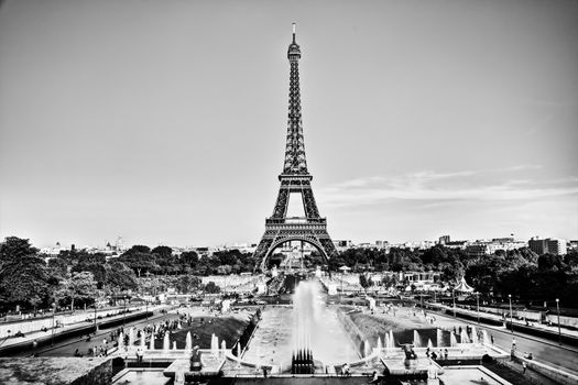 Eiffel Tower seen from fountain at Jardins du Trocadero at a sunny summer day, Paris, France. Black and white