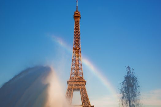 Eiffel Tower seen from fountain making natural rainbow at Jardins du Trocadero at a sunny summer day, Paris, France