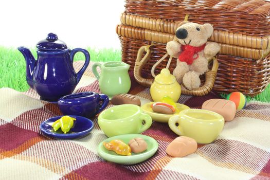 picnic with wicker basket, blanket and dishes on a light background