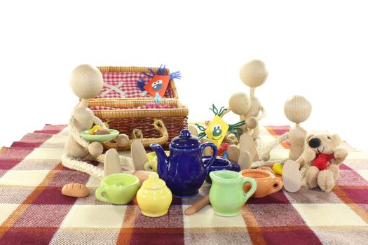 Picnic with family, kite, wicker basket, blanket and dishes on a light background