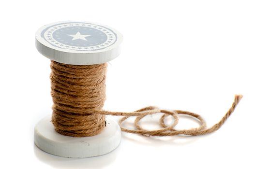 a spool of rope in the color brown on a white background