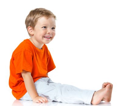 Adorable happy boy sitting on the floor in studio. Isolated of white background.