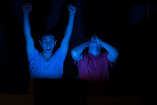 Two guys in front of a computer screen getting all excited about something