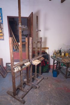 Easel surrounded by objects in a painters atelier
