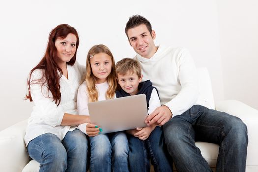 Happy family spending time together and using laptop at home