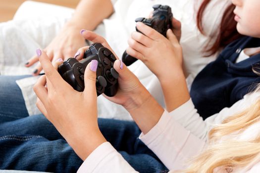 Closeup on kids hands playing console games using joystick