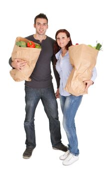 Happy couple with grocery shopping bags. Isolated on white