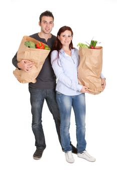 Happy couple with grocery shopping bags. Isolated on white