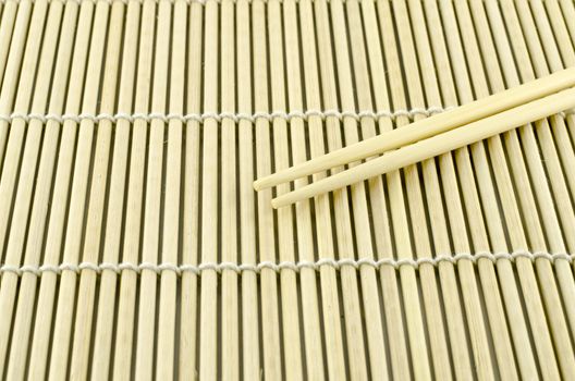 Two chopsticks on sushi mat background for menu