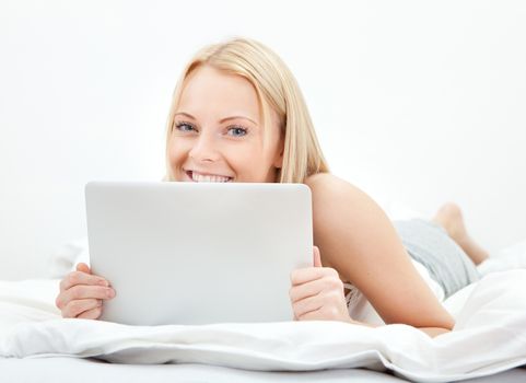 Young beautiful woman using laptop in bed at home