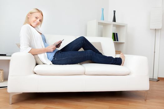 Beautiful woman working on computer sitting in sofa