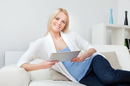 Beautiful woman working on computer sitting in sofa