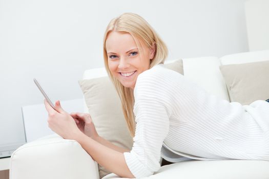 Beautiful woman working on computer sitting in sofa