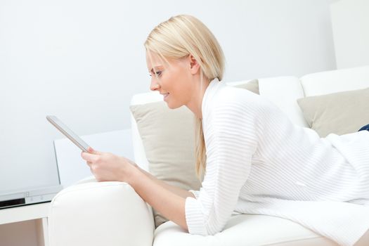 Beautiful woman working on computer sitting in sofa