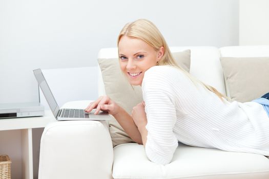 Beautiful woman working on computer sitting in sofa