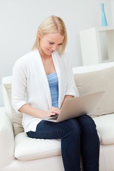 Beautiful woman shopping online with laptop sitting in sofa