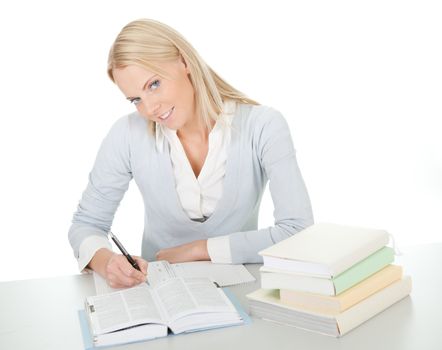 Beautiful student girl doing homework at the desk. Isolated on white