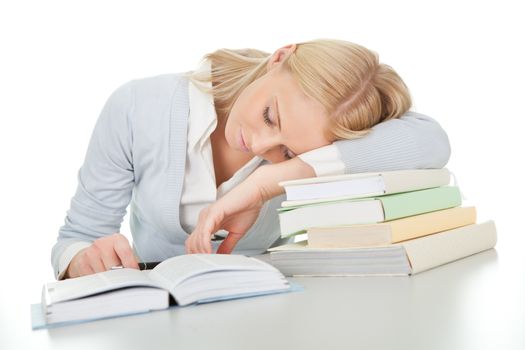 Beautiful student girl tired from doing homework at the desk. Isolated on white