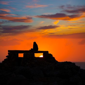 Ciutadella Menorca at Punta Nati orange sunset with girl backlight