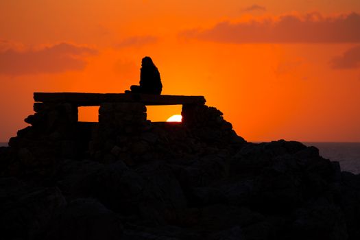 Ciutadella Menorca at Punta Nati orange sunset with girl backlight