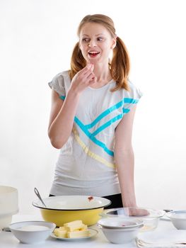 The beautiful young cheerful girl on home cuisine cooks dough for easter pie