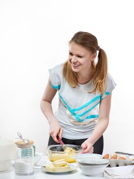 The beautiful young cheerful girl on home cuisine cooks dough for easter pie