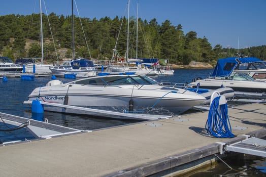 The boat is moored to the dock at the Osco marina in Halden, Norway.