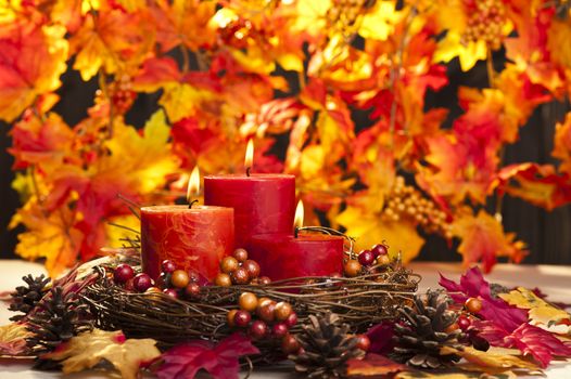 Candles in nice and beautiful colorful autumn leaves