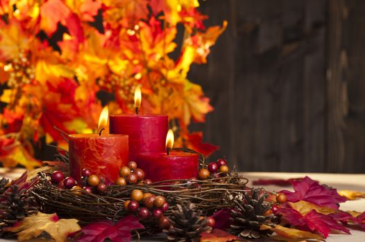 Candles in nice and beautiful colorful autumn leaves