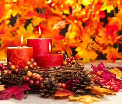 Candles in nice and beautiful colorful autumn leaves