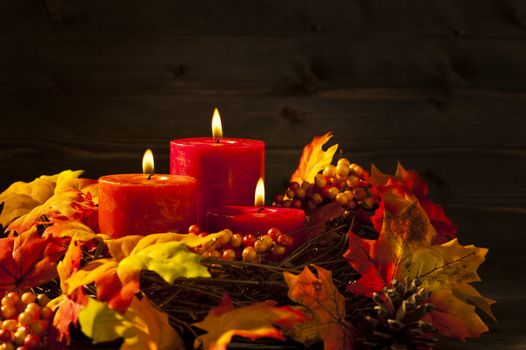 Candles in nice and beautiful colorful autumn leaves