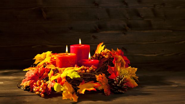 Candles in nice and beautiful colorful autumn leaves