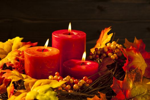 Candles in nice and beautiful colorful autumn leaves