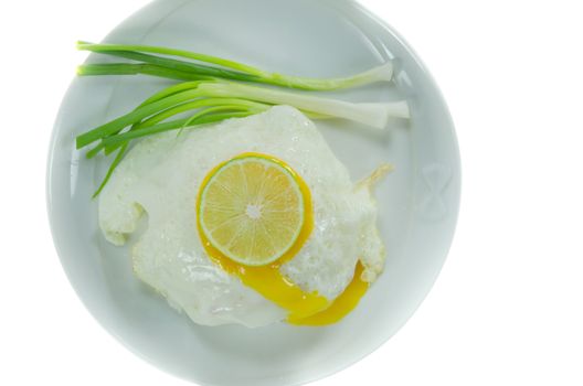 top view fried egg with fresh vegetable  and slice lime on dish over white background