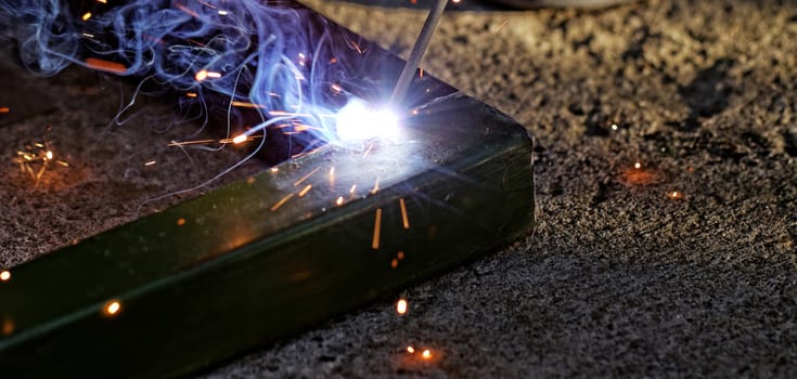 Iron welding with bright light and smoke at manufacturing