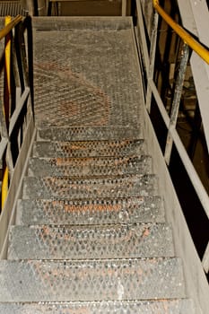 old rusty industrial staircase with yellow fence