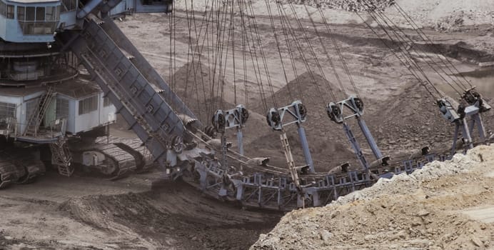 Coal mining in an open pit with huge industrial machine