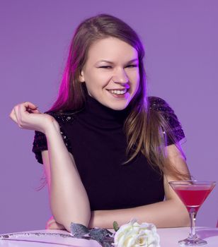 Happy young woman with cocktail at restaurant