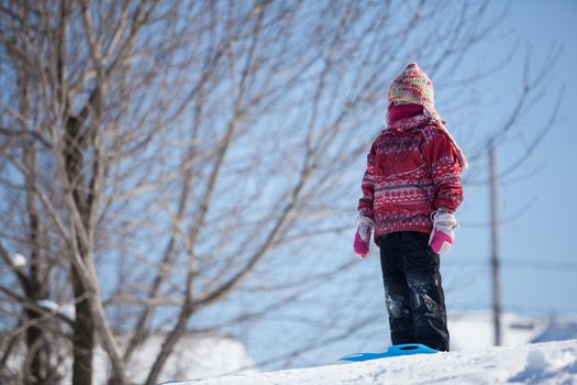 Girl sliding down a hill in the snow