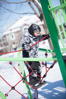 Boy in a playground on a cold winter day